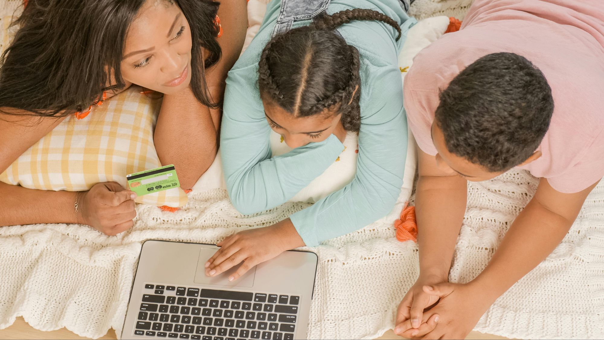 A family relaxing on the floor, gathered around a laptop to explore Zulily alternatives for their online shopping needs.
